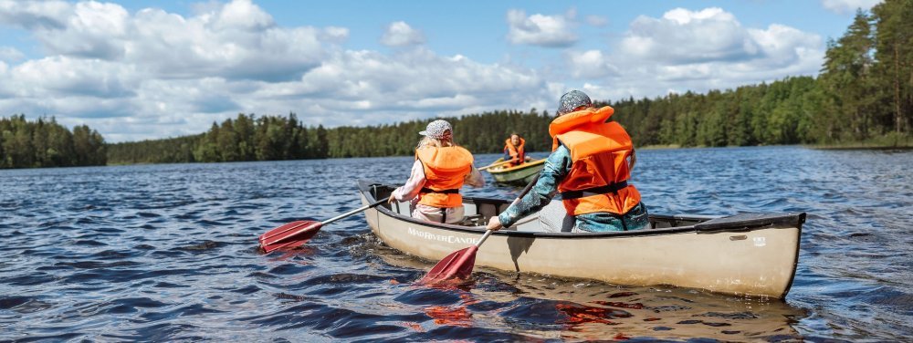 Kuvassa leiriläiset soutaa järvellä.