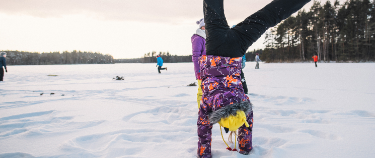 Leiriläinen seisoo käsillä talvilomalla